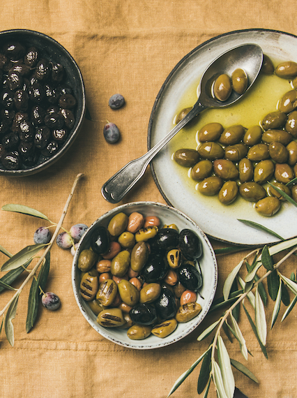 Grüne, braune und schwarze Oliven in Olivenöl eingelegt